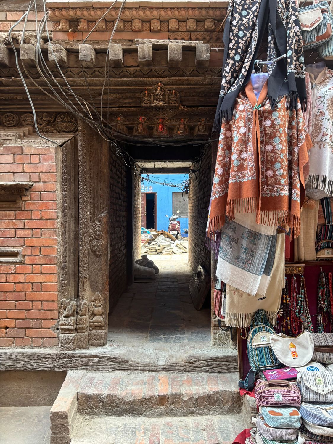 The carved wooden passageway into Gwakhancha, between a brick house and a shawl shop